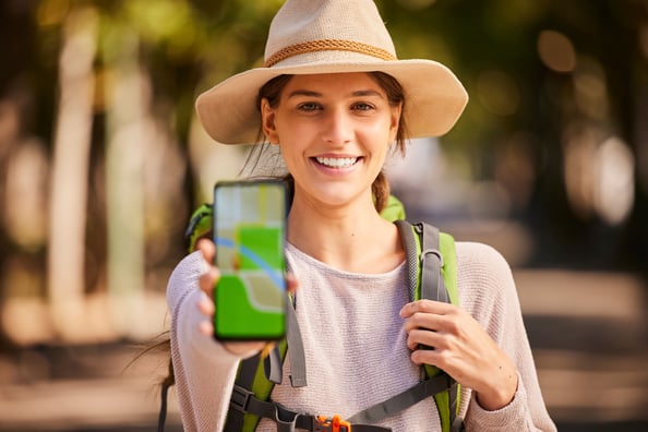 mujer-con-sombrero-de-aventura-mostrando-su-celular-con-aplicacion-para-viajar-en-australia